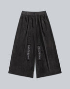 Clotechnow black wide-leg Harajuku hakama pants with textured fabric and decorative embroidered front detailing.