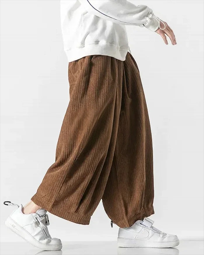 Clotechnow brown corduroy wide-leg hakama pants with a draped silhouette worn with white sneakers