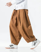Clotechnow brown wide-leg hakama pants with a draped silhouette worn with white sneakers on a model