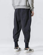 Clotechnow Cobalt Flow Hakama pants in dark blue with a wide-leg draped silhouette and cuffed ankles, back view.