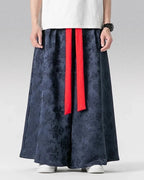 Clotechnow dark blue wide-leg hakama pants with a subtle glyph pattern and contrasting red waist tie straps