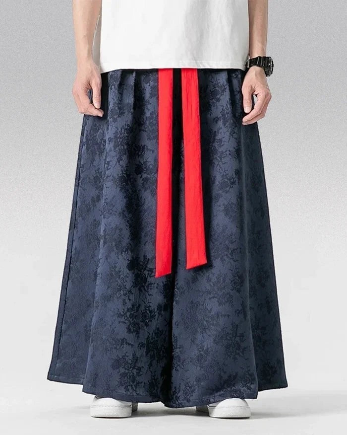 Clotechnow dark blue wide-leg hakama pants with a subtle glyph pattern and contrasting red waist tie straps