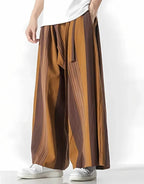 Clotechnow earth tone striped hakama pants with a wide-leg draped silhouette worn with white sneakers