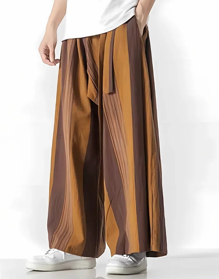 Clotechnow earth tone striped hakama pants with a wide-leg draped silhouette worn with white sneakers