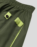 Clotechnow forest green hakama pants featuring lime green pocket accents and black button details