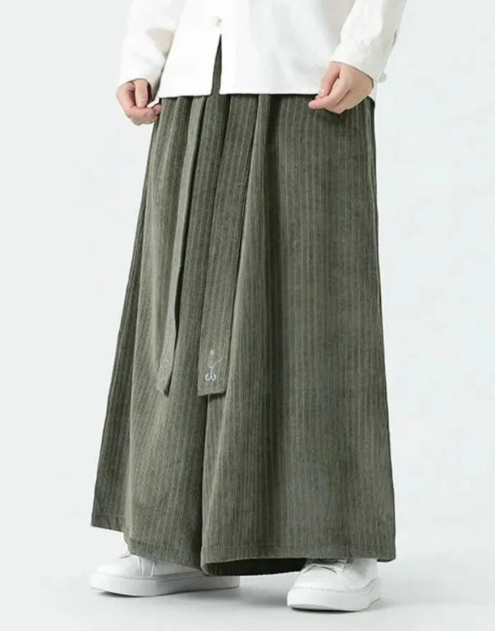 Clotechnow green wide-leg hakama pants with vertical texture and draped silhouette worn with white sneakers