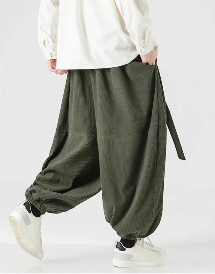 Clotechnow green corduroy wide-leg hakama pants with ribbon tie waist and elastic cuffs worn with white sneakers