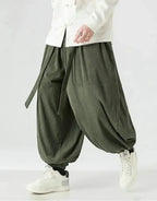 Clotechnow green corduroy hakama pants with a ribbon tie waist and wide-leg draped silhouette worn with white sneakers
