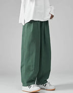 Clotechnow wide-leg green Hakama pants with a draped silhouette worn with a white top and sneakers