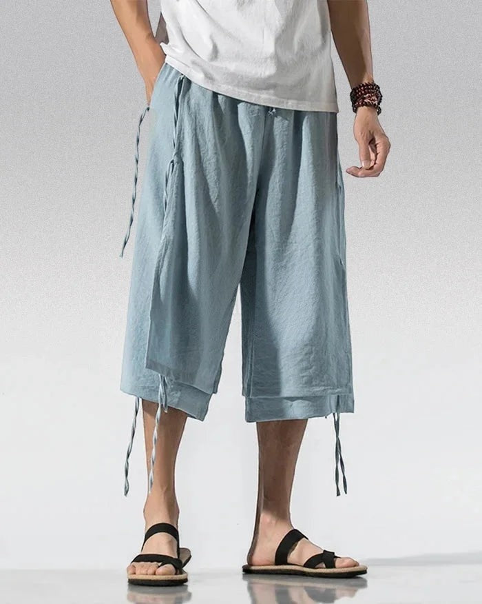 Clotechnow light blue wide-leg sarouelle hakama pants with draped fabric and side tie details on a male model