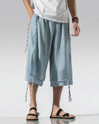 Clotechnow light blue wide-leg sarouelle hakama pants with draped fabric and side tie details on a male model