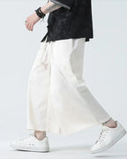 Clotechnow pale modern hakama pants with a wide-leg silhouette and drawstring waist worn with white sneakers