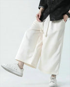 Clotechnow pale wide-leg hakama pants with a drawstring waist, styled with a black top and white sneakers.
