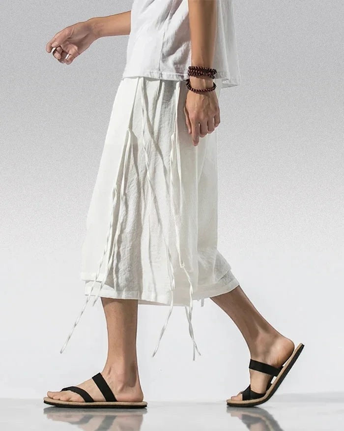 Clotechnow white Sarouelle drape hakama pants with wide-leg silhouette and side tie details worn with black sandals