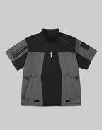 Black and gray techwear t-shirt with geometric color blocking and visual pocket accents creating an elongated avant-garde silhouette — view 1