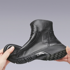 Hands holding a black leather boot in a bending demonstration