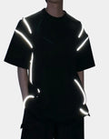Black and white techwear t-shirt featuring a patterned light-responsive surface that brightens under illumination in urban styling — view 1