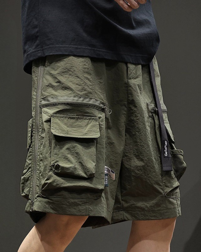 Green cargo shorts with multiple pockets on a dark background