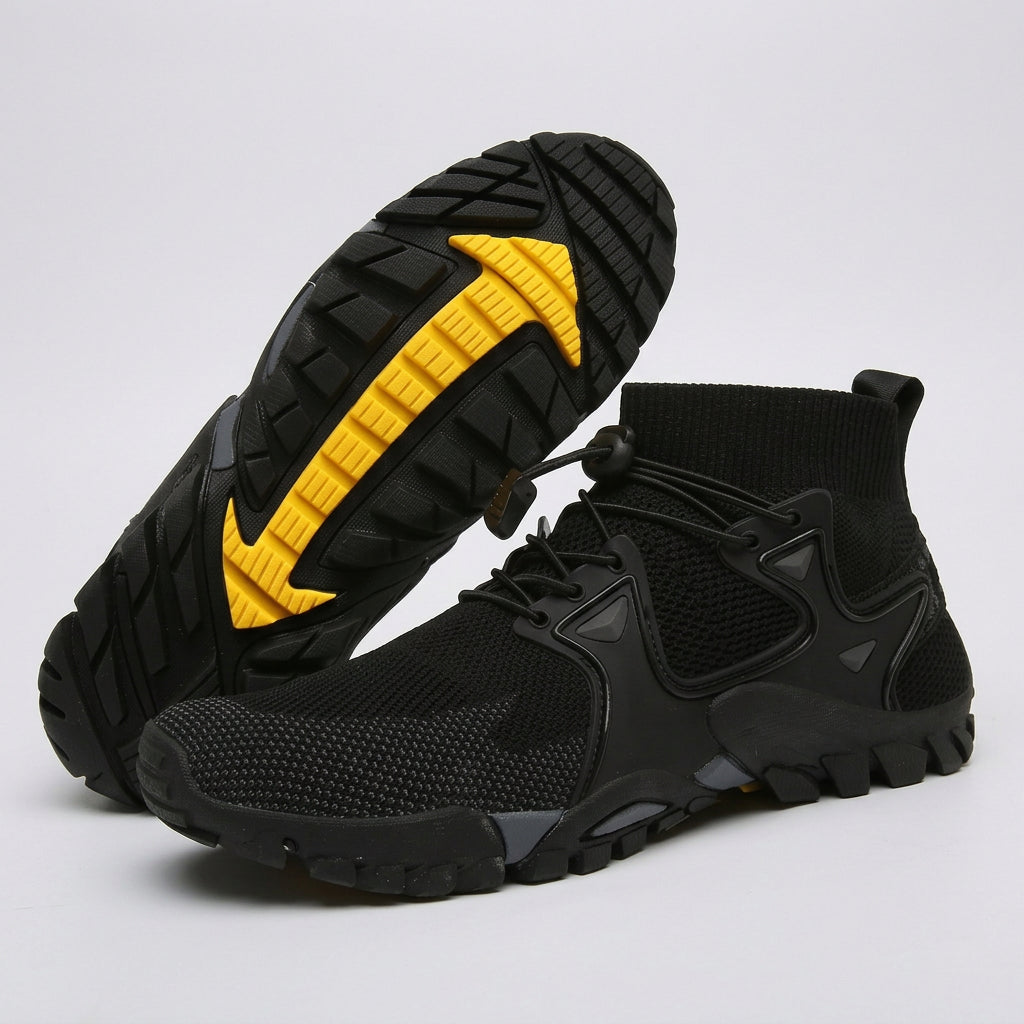 A pair of black athletic ankle boots with a textured knit upper, black laces, and a prominent bright yellow accent on the outsole, shown on a light gray background.