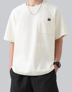 White short-sleeve techwear t-shirt with prominent black clip-closure front pocket and minimalist urban design details — view 4