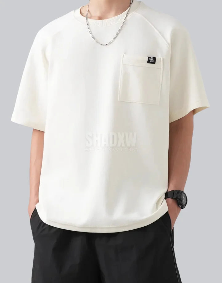 White short-sleeve techwear t-shirt with prominent black clip-closure front pocket and minimalist urban design details — view 4
