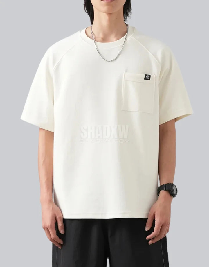 White short-sleeve techwear t-shirt with prominent black clip-closure front pocket and minimalist urban design details — view 3