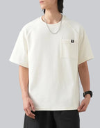 White short-sleeve techwear t-shirt with prominent black clip-closure front pocket and minimalist urban design details — view 1