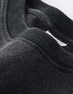 Oversized washed black techwear t-shirt with a long hem, muted charcoal finish, and minimalist urban streetwear styling — view 7
