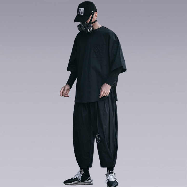 Man wearing THE DARK UNISEX TECHWEAR T-SHIRT and a Black Harem pants